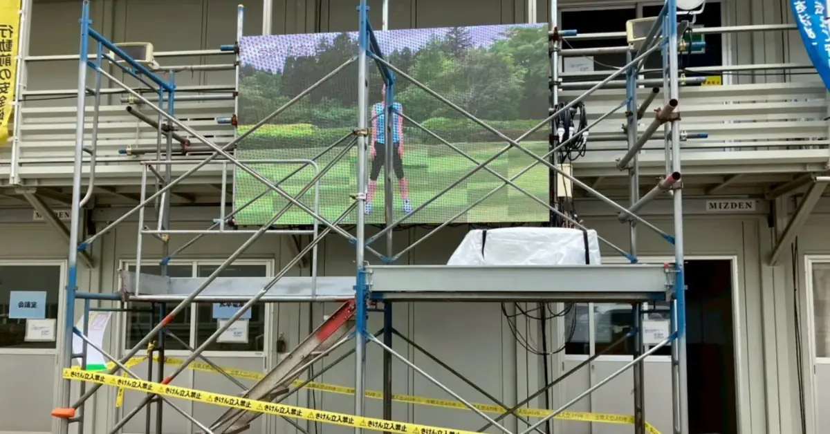 現場事務所の足場に設置し、体操の映像を流しているLEDビジョン